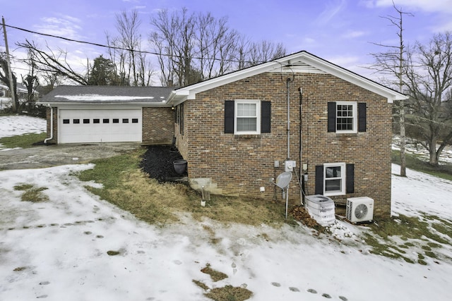 view of front of home with ac unit and a garage