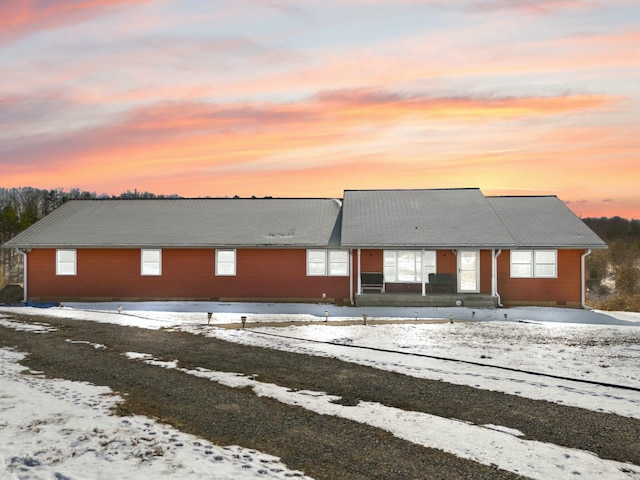 view of snow covered back of property