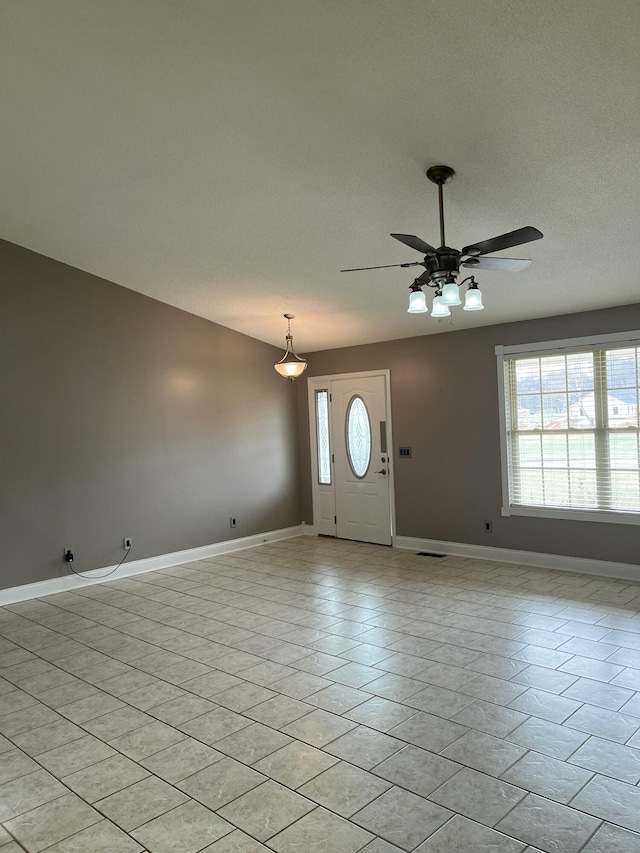 entrance foyer featuring ceiling fan, plenty of natural light, and light tile patterned floors