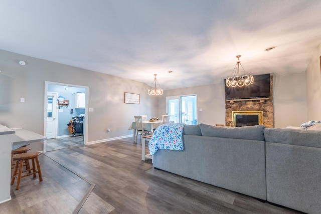 1216 Maple Hill Dr, Somerset, KY 42503 - living area featuring wood finished floors, a chandelier, a stone fireplace, and baseboards
