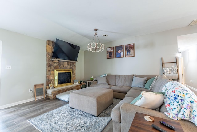 1216 Maple Hill Dr, Somerset, KY 42503 - living room featuring wood finished floors, baseboards, a stone fireplace, and a chandelier