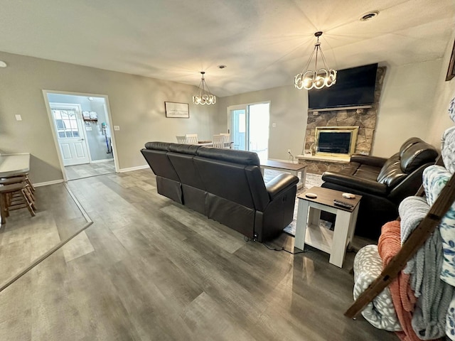 living room with wood-type flooring, a fireplace, and a chandelier