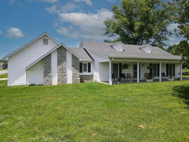 back of property with covered porch and a yard