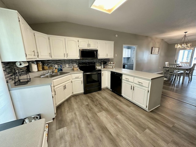 kitchen featuring white cabinetry, pendant lighting, kitchen peninsula, and black appliances