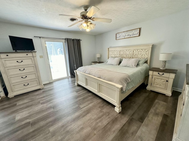 bedroom featuring a textured ceiling, ceiling fan, dark hardwood / wood-style floors, and access to outside