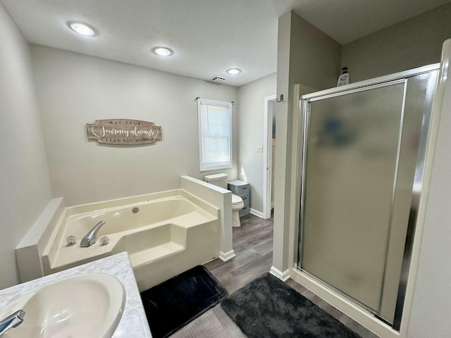 full bathroom with sink, wood-type flooring, toilet, and independent shower and bath