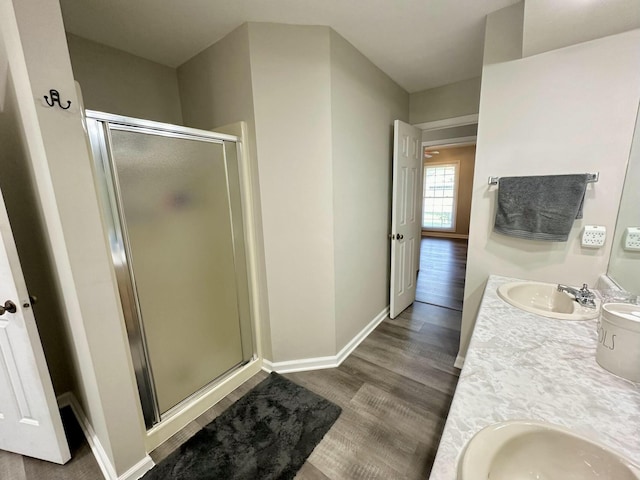 bathroom featuring a shower with shower door, hardwood / wood-style floors, and vanity