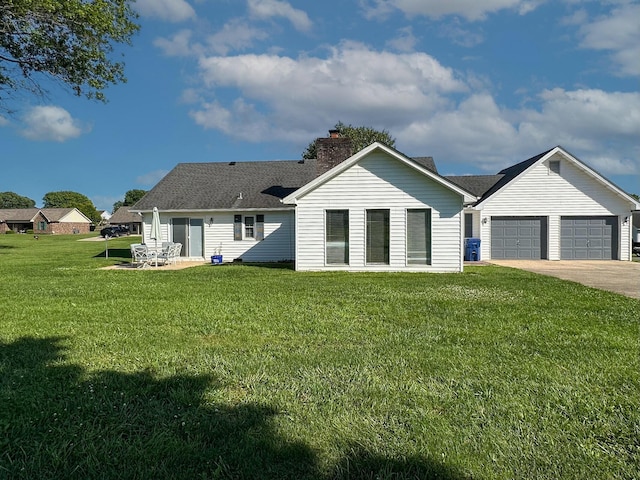 back of house featuring a yard and a garage