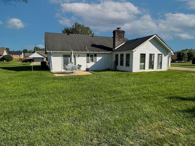 rear view of property with a yard and a patio