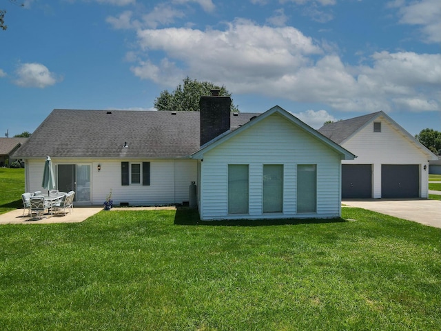 rear view of property with a patio area, a yard, and a garage