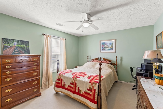 carpeted bedroom featuring a textured ceiling and ceiling fan