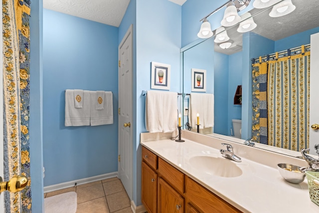 bathroom featuring vanity, a textured ceiling, tile patterned floors, and toilet