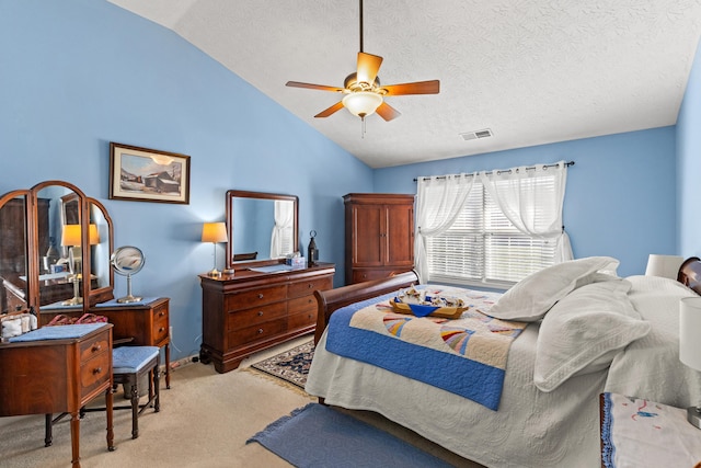 bedroom with ceiling fan, lofted ceiling, light carpet, and a textured ceiling