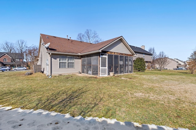 rear view of house with a sunroom and a lawn