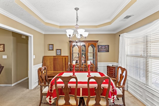 carpeted dining room featuring an inviting chandelier, a tray ceiling, and a textured ceiling