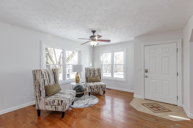 sitting room featuring ceiling fan, a textured ceiling, and hardwood / wood-style flooring