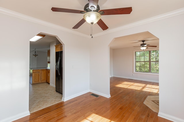 spare room featuring ornamental molding and light hardwood / wood-style floors