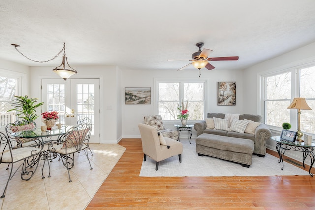 living room featuring ceiling fan, french doors, and light tile patterned flooring