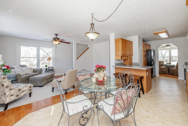 dining area with ceiling fan, a textured ceiling, and light hardwood / wood-style floors