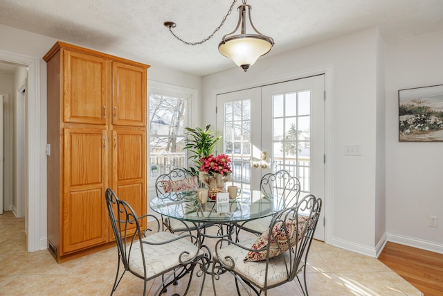 dining area featuring a textured ceiling, light tile patterned floors, and french doors