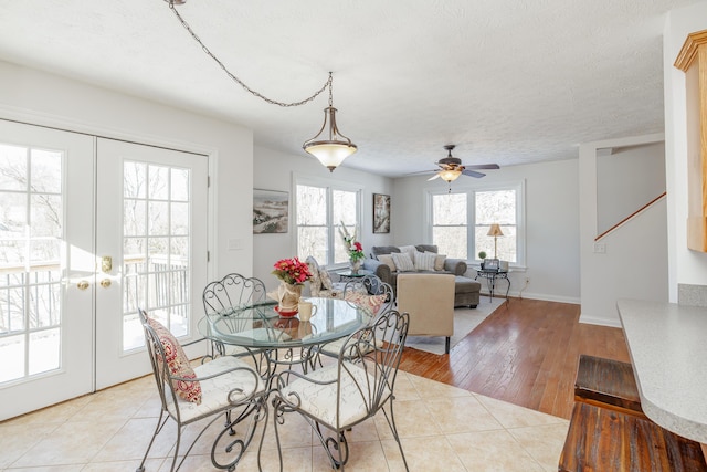 dining space with ceiling fan, french doors, a textured ceiling, and light hardwood / wood-style flooring