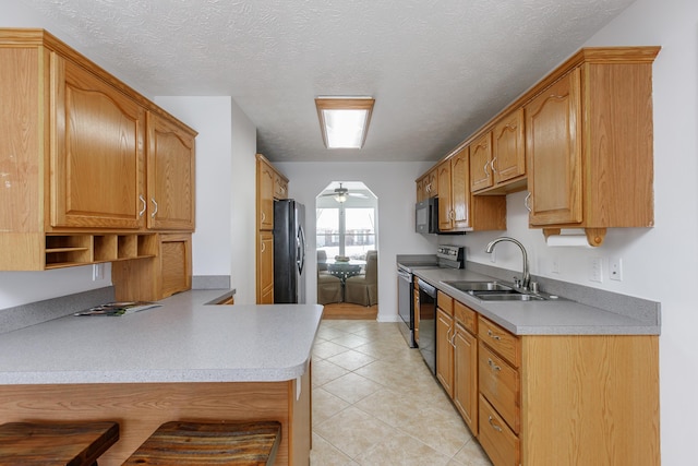 kitchen featuring kitchen peninsula, ceiling fan, a textured ceiling, black appliances, and sink