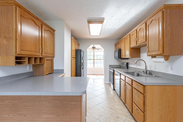 kitchen with a textured ceiling, stainless steel appliances, sink, ceiling fan, and light tile patterned floors