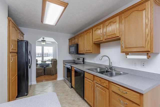 kitchen with ceiling fan, black appliances, sink, a textured ceiling, and light tile patterned floors