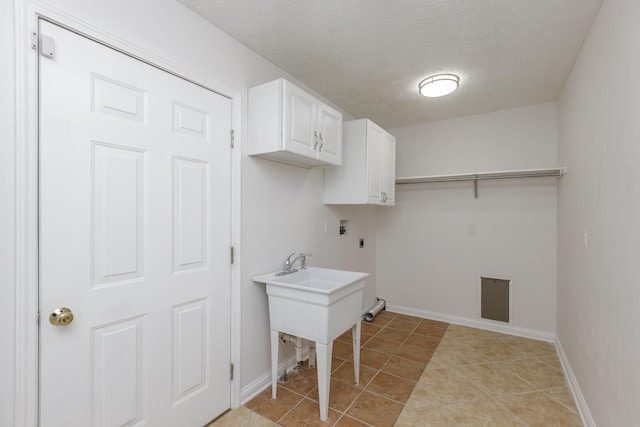 laundry room with light tile patterned flooring, washer hookup, a textured ceiling, electric dryer hookup, and cabinets