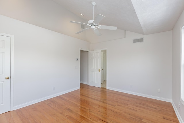 empty room featuring ceiling fan, lofted ceiling, and light wood-type flooring