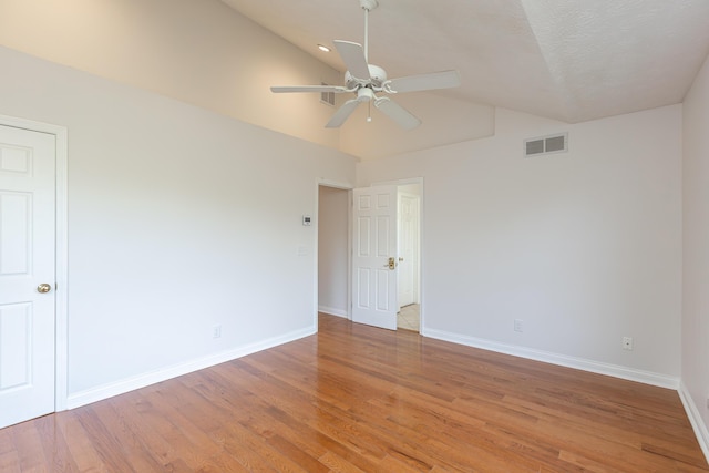 empty room with vaulted ceiling, ceiling fan, and hardwood / wood-style floors