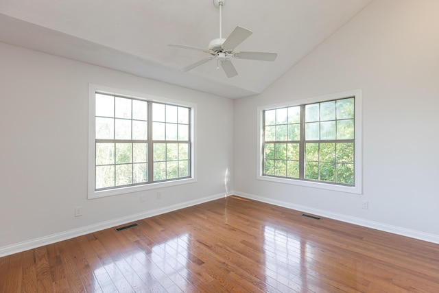 spare room with ceiling fan, vaulted ceiling, plenty of natural light, and hardwood / wood-style floors