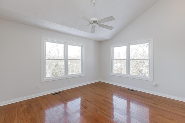 empty room with vaulted ceiling, ceiling fan, and hardwood / wood-style flooring