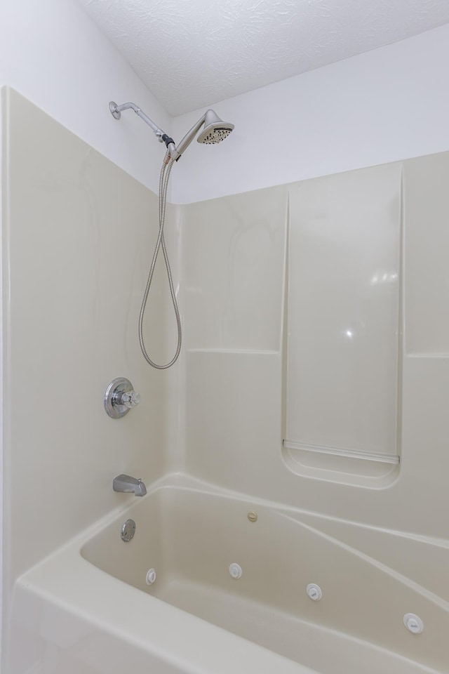 bathroom with shower / bathtub combination and a textured ceiling