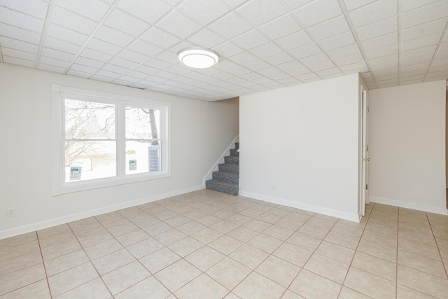 interior space featuring light tile patterned floors and a drop ceiling