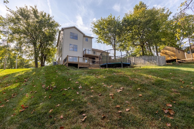 view of yard featuring a trampoline and a wooden deck