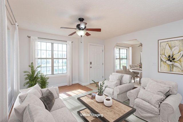 living room featuring ceiling fan, plenty of natural light, and light wood-type flooring