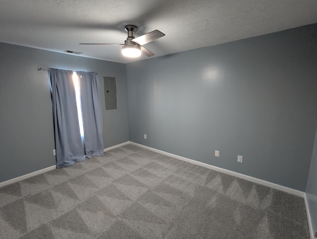 carpeted empty room with ceiling fan, electric panel, and a textured ceiling