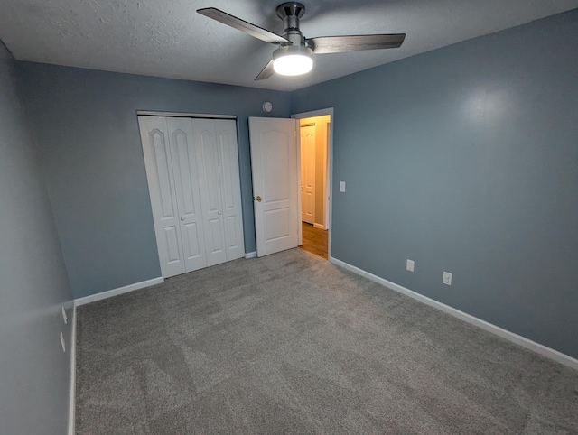 unfurnished bedroom featuring carpet, a textured ceiling, ceiling fan, and a closet