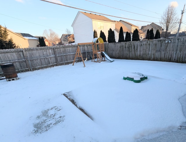 snowy yard featuring a playground