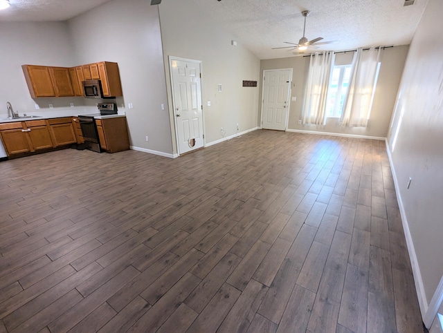 unfurnished living room featuring sink, a textured ceiling, dark wood-type flooring, and ceiling fan