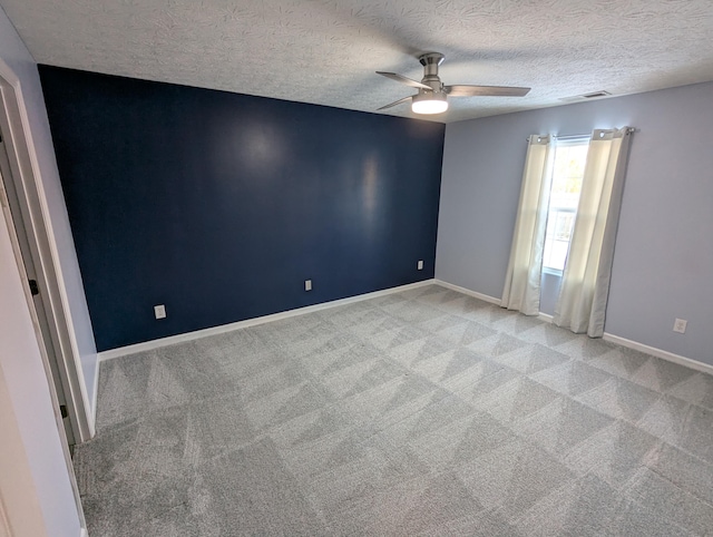 carpeted empty room with ceiling fan and a textured ceiling