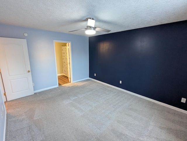 empty room featuring ceiling fan, carpet floors, and a textured ceiling