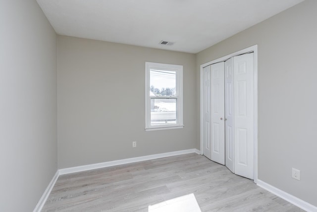 unfurnished bedroom featuring light hardwood / wood-style flooring and a closet