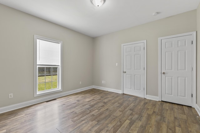 unfurnished bedroom with dark hardwood / wood-style flooring