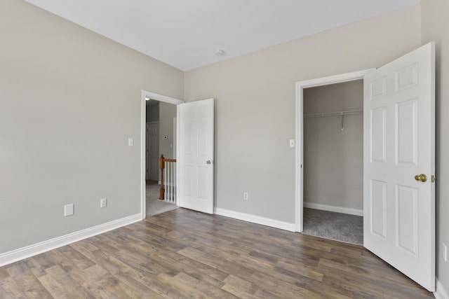 unfurnished bedroom featuring a closet and dark hardwood / wood-style flooring