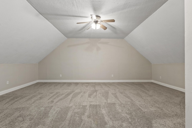 additional living space featuring a textured ceiling, ceiling fan, carpet flooring, and lofted ceiling