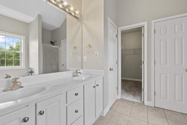 bathroom with an enclosed shower, vanity, and tile patterned flooring