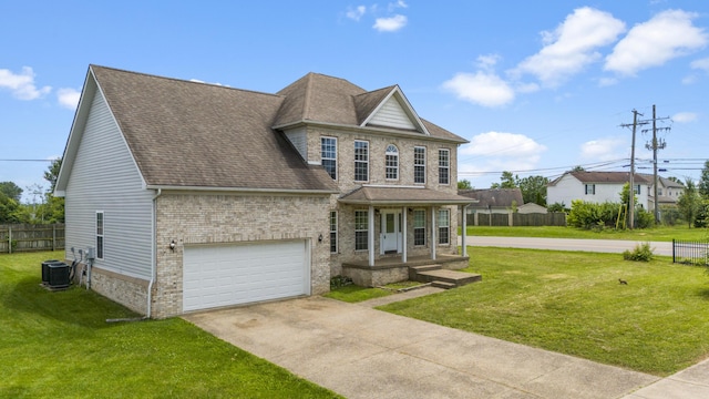 view of front of house featuring a garage, a front yard, and central AC