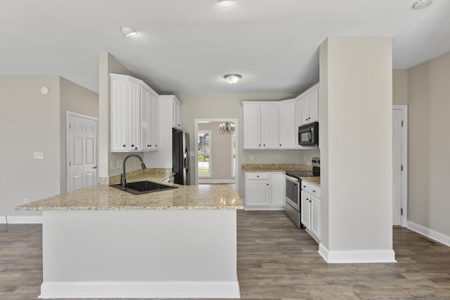 kitchen with white cabinetry, electric range, light stone countertops, refrigerator, and sink